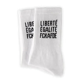 Die Arrel FCKAFDÉ Statement Socken in Weiß sind gerippte Socken aus Bio-Baumwolle mit dem Text "LIBERTÉ ÉGALITÉ FCKAFDÉ" in Schwarz an den Seiten und flach auf weißem Grund.