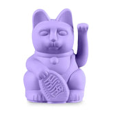 Die Glückskatze - Winkekatze lila von Donkey Products ist eine lavendelfarbene Figur mit einer erhobenen Pfote und einer ovalen Münze, die als charmanter Glücksbringer dient und das Glück symbolisiert.