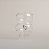 Die Vase Double Bubble Glas "Herz" von Eulenschnitt besticht durch ihr klares, geschwungenes Design mit einem schlichten schwarzen Herz auf der Vorderseite - ein stilvolles Geschenk für jeden Anlass.