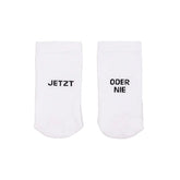 Die Eulenschnitt Socken "Jetzt oder Nie" weiß aus Bio-Baumwolle zeigen links "JETZT" und rechts "ODER NIE" - stylische Socken inspiriert vom Motto "Now or never".