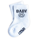 Die Socken "Baby" von Loones sind weiße Babysocken mit BABY und einem Smiley in Schwarz auf der Oberseite und LOONES auf der Sohle. Hergestellt aus Bio-Baumwolle für nachhaltigen Komfort und Gemütlichkeit.
