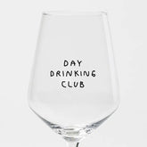 Das "Day Drinking Club" Weinglas von Johanna Schwarzer aus dem Hause Selekkt zeigt einen verspielten, handgeschriebenen schwarzen Text auf einer klaren Schale mit Siebdruck vor einem schlichten weißen Hintergrund - ideal für Fans von exklusiven Weingläsern.