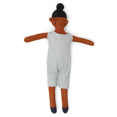 Die Stoffpuppe "Buddy Aqua" Baumwolle von Sophie Home hat mittelbraune Haut, schwarzes Haar in einem Dutt, einen hellgrauen ärmellosen Strampler und dunkle Schuhe - gefertigt aus Baumwollstrick mit ausgestreckten Armen und einem Lächeln auf weißem Hintergrund.