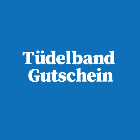 Weißer Text auf blauem Grund: Tüdelband Gutschein in fetter Serifenschrift - das ideale Geschenk von Tüdelband Winsen für besondere Geschenke wie Design-Gläser oder Eulenschnitt-Becher.