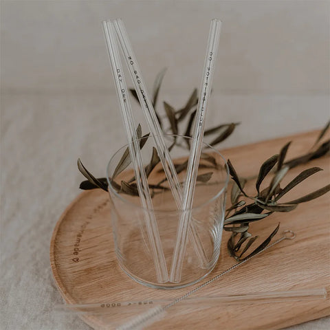 Die schwarzen Glasstrohhalme "No Bad Days" von Eulenschnitt (20 cm, 4er Set) sind stilvoll im Glasbecher auf Holztablett mit Olivenzweigen dekoriert - die nachhaltige Alternative für umweltbewusstes Trinken.