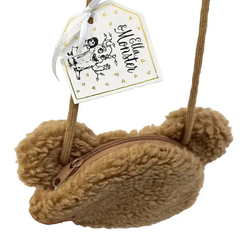 Die Tasche "Teddy" Kunstfell braun von Ella & Monster ist ein kleiner, brauner Geldbeutel mit Bärengesicht, runden Ohren, Reißverschluss und Kordelzug. Ein weißer Anhänger mit dem Ella & Monster-Logo ist angebracht - ein süßes Kinder-Accessoire für jedes Kind.