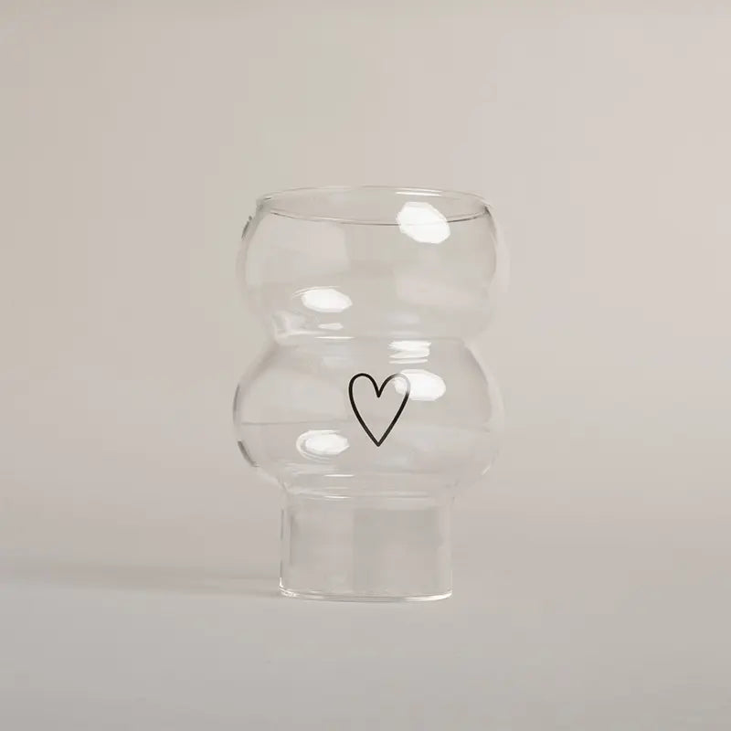 Die Vase Double Bubble Glas "Herz" von Eulenschnitt besticht durch ihr klares, geschwungenes Design mit einem schlichten schwarzen Herz auf der Vorderseite - ein stilvolles Geschenk für jeden Anlass.