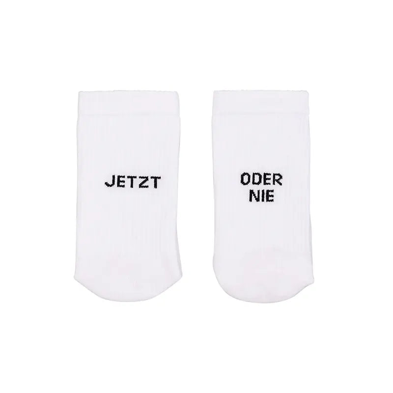 Die Eulenschnitt Socken "Jetzt oder Nie" weiß aus Bio-Baumwolle zeigen links "JETZT" und rechts "ODER NIE" - stylische Socken inspiriert vom Motto "Now or never".