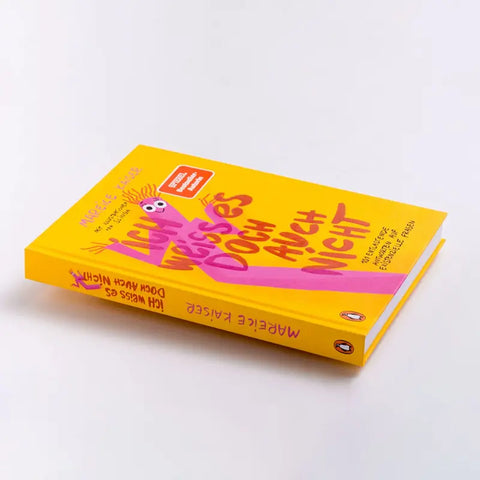 Das im Penguin Verlag erschienene Buch "Ich weiß es doch auch nicht" von Mareice Kaiser, ein gelber Ratgeber mit buntem Cover, liegt schräg auf weißem Untergrund und thematisiert Feminismus in 101 entlastenden Antworten.