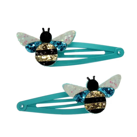 Das 2er Set "Hummel" Glitzer-Haarspangen von Rex London besticht mit Bienen-Motiven: weiße Flügel, blau-gold gestreifter Körper, schwarze Fühler - tolle Geschenkidee! Die Bienen sitzen am Ende jeder Spange.
