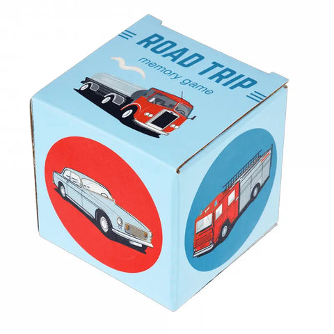 Eine blaue Pappschachtel mit der Aufschrift "Memory-Spiel Road Trip (24-teilig)" von Rex London, mit Fahrzeugillustrationen (Feuerwehrauto, Oldtimer, Anhänger) auf den Seiten und dem Deckel - perfekt für Kinder.