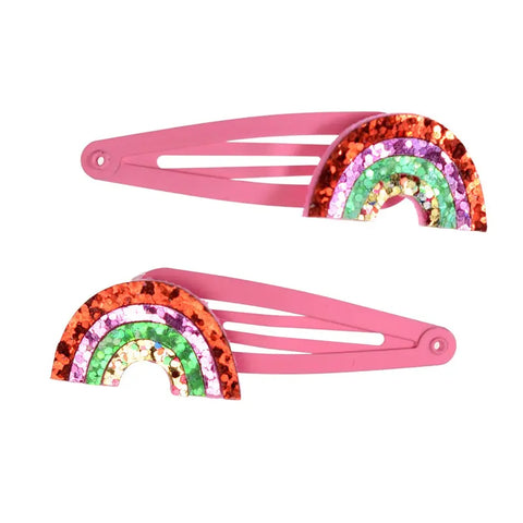 Das 2er-Set "Regenbogen" Glitzer-Haarspangen von Rex London umfasst zwei pinke Spangen, verziert mit dekorativen, glitzernden Regenbögen in Rot, Pink, Grün und Silber - ideal als Geschenkidee.