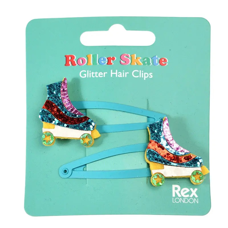 Zwei "Rollschuh" Glitzer-Haarspangen (2er Set) von Rex London, mit bunten Details und gelben Rädern, sind auf einer türkisfarbenen Karte befestigt - ein perfektes Geschenk für Retro-Fans.
