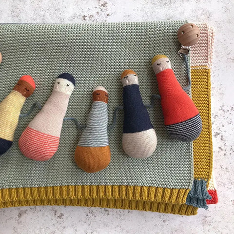 Die Kinderwagenkette "Püppchen" Baumwolle von Sophie Home besteht aus sechs weichen, farbenfrohen Puppen mit gestickten Gesichtern auf grünem Grund und gelb-roten Häkelkanten - ein niedliches Accessoire für die Kleinsten.