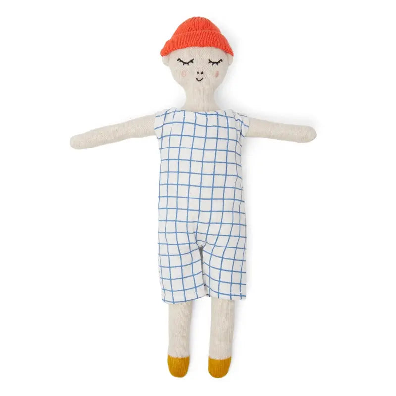Die Sophie Home Stoffpuppe "Buddy Grid" Baumwolle ist eine weiche, gestrickte Kuschelpuppe mit lächelndem Gesicht, roter Mütze, blau-weißem Gitterstrampler und gelben Schuhen, die mit ausgestreckten Armen auf weißem Hintergrund dargestellt ist.