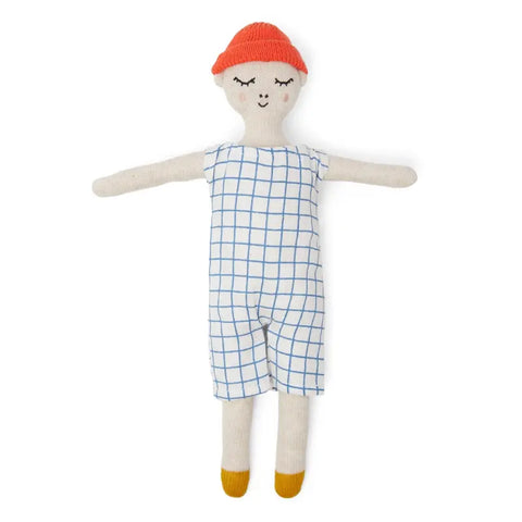 Die Sophie Home Stoffpuppe "Buddy Grid" Baumwolle ist eine weiche, gestrickte Kuschelpuppe mit lächelndem Gesicht, roter Mütze, blau-weißem Gitterstrampler und gelben Schuhen, die mit ausgestreckten Armen auf weißem Hintergrund dargestellt ist.