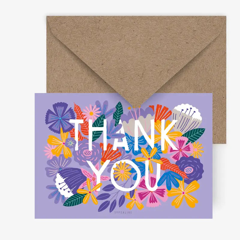 Die Postkarte Bloomy Thanks" von Typealive zeigt farbenfrohe, illustrierte Blumen und einen fetten, weißen Danksagungstext auf lavendelfarbenem Hintergrund. Sie ist mit einem Kraftumschlag versehen - ideal zum Verschenken oder für eine stilvolle Karte.